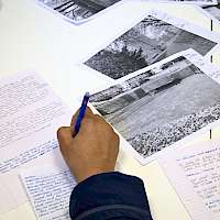 Black and white photos spread out on a desk.
